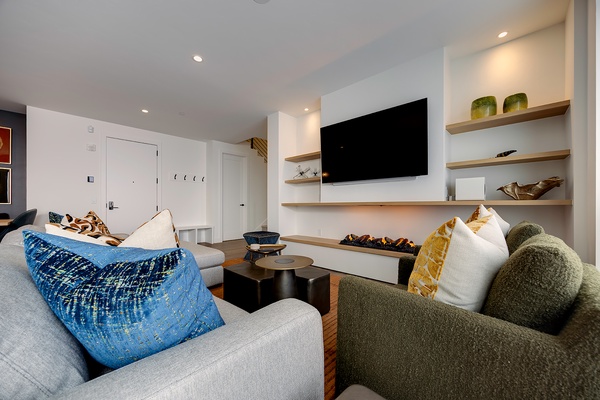 Sink into plush seating and unwind in your stylish living area, complete with a cozy electric fireplace and modern entertainment setup for relaxing evenings in.