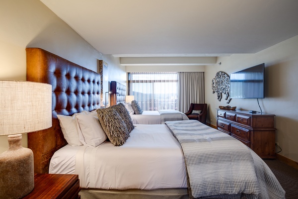 Settle into crisp linens and luxurious tufted headboards as natural light pours through your suite—perfect for unwinding after exploring the area.