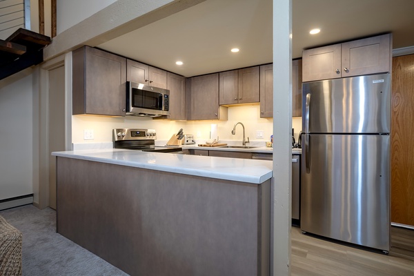 Your modern kitchen features stainless steel appliances, sleek countertops, and warm ambient lighting—perfect for preparing home-cooked meals during your stay.