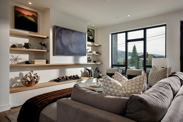Sink into plush seating and enjoy mountain views framed by expansive windows. Your living room invites relaxation with its cozy fireplace and thoughtful design touches.