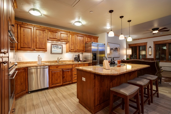 Your gourmet kitchen awaits with rich wood cabinetry, granite countertops, stainless steel appliances, and a spacious island where you can gather to cook and share memorable meals together.