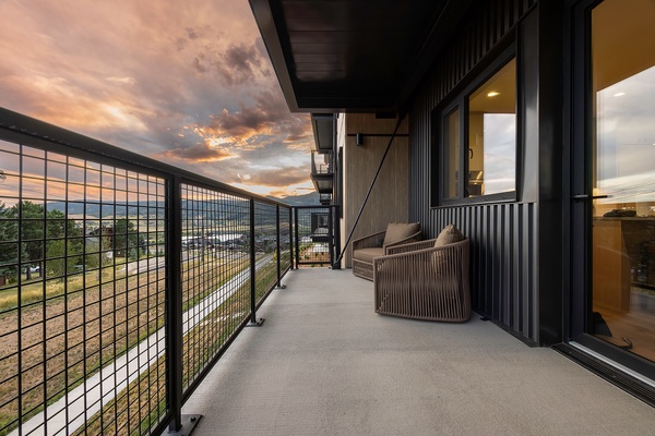 Settle into your private balcony as the sky transforms into soft shades of peach and gold. The cozy seating invites you to unwind, while mountain silhouettes rise in the distance—perfect for morning coffee or evening reflections.