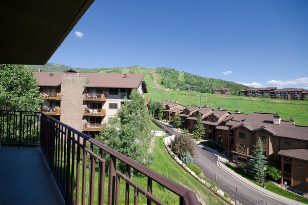 Mountain resort setting with ski slopes and neighboring properties visible from the surrounding area, showcasing the property's alpine location and scenic hillside neighborhood.