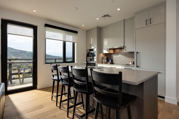 Gather at the sleek kitchen island where stunning mountain views frame your morning coffee. Stylish bar seating invites conversation while you cook in this modern, light-filled space that flows effortlessly to your private balcony.