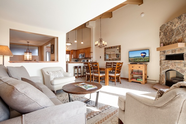 Relax in your bright, open living area with soaring ceilings, cozy stone fireplace, and plush seating perfect for gathering after a day of adventure.