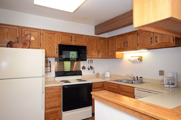 Your well-equipped kitchen features oak cabinetry, full-size appliances, and generous counter space—perfect for preparing your morning coffee or family meals in comfort.
