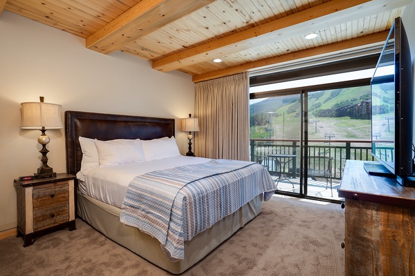 Wake up to mountain vistas framed by your private balcony. Sink into crisp linens under exposed beams, where modern comfort meets alpine charm in your cozy retreat.