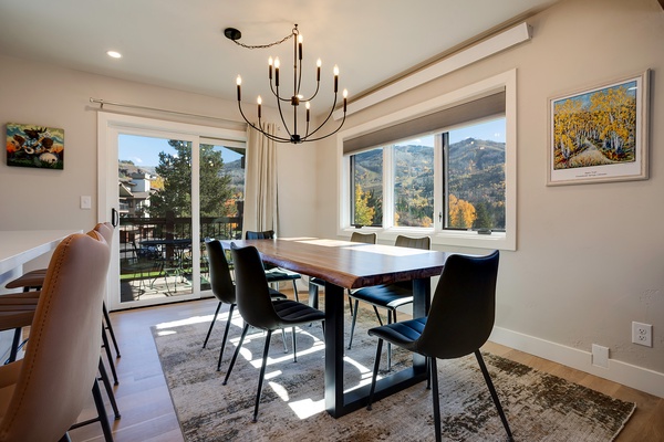 Gather around this elegant dining table with mountain views framing your meals, where natural light and autumn colors create the perfect backdrop for your memorable moments together.