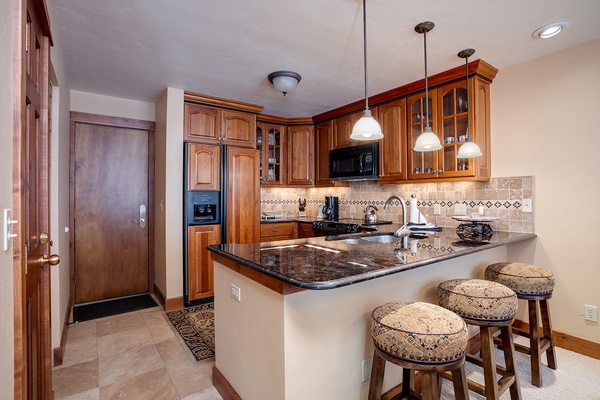Your fully equipped kitchen welcomes you with elegant wood cabinetry, granite countertops, and a breakfast bar—perfect for preparing meals or enjoying morning coffee in comfort.