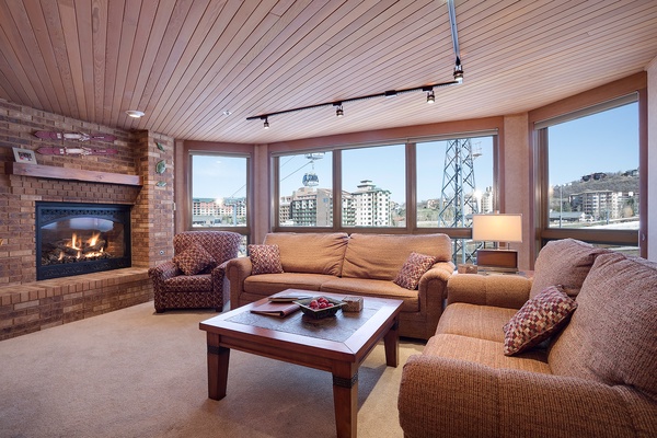 Unwind in your cozy living space, where a crackling fireplace meets breathtaking mountain views—your perfect retreat after a day on the slopes.