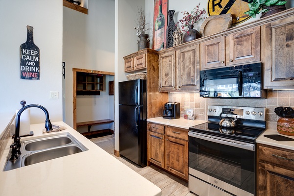 Your fully equipped kitchen features rustic wood cabinetry, modern appliances, and charming details—perfect for preparing meals at home after exploring the area.