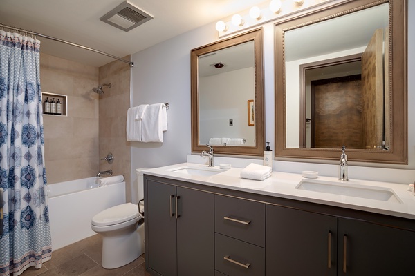 Your private bathroom features dual vanities, soft lighting, and a tub-shower combo where you can unwind after a day exploring.