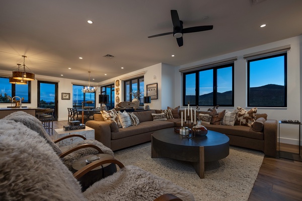 Sink into plush seating and watch twilight paint the mountains beyond your windows—this open-concept living space blends warmth, style, and stunning vistas for your ultimate mountain retreat.