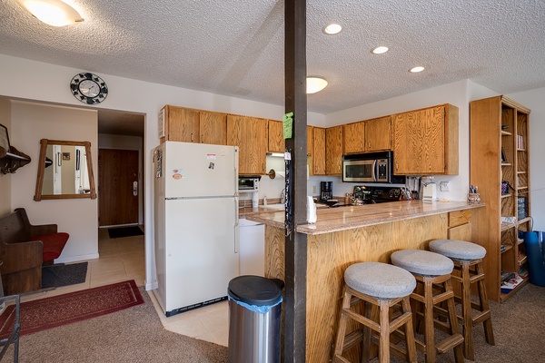 Your fully-equipped kitchen awaits with everything you'll need—stove, microwave, coffee maker, and ample counter space for preparing meals during your stay.