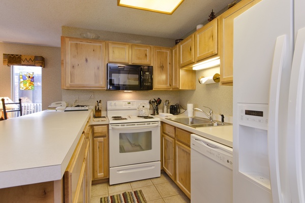 Your fully equipped kitchen awaits with warm wood cabinetry, modern appliances, and everything you need to prepare memorable meals during your stay.