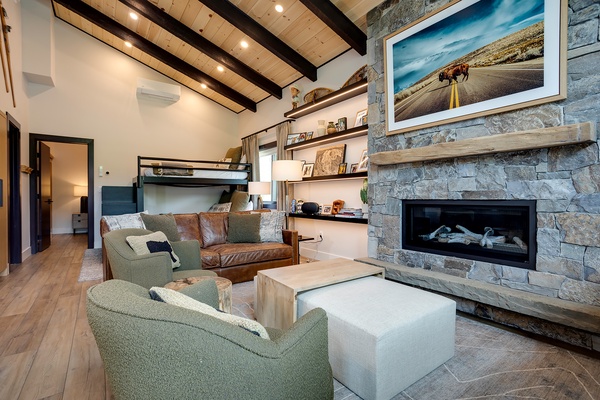 Cozy up in your open-concept living room with rustic exposed beams, stone fireplace, and thoughtful sleeping arrangements for the whole family.