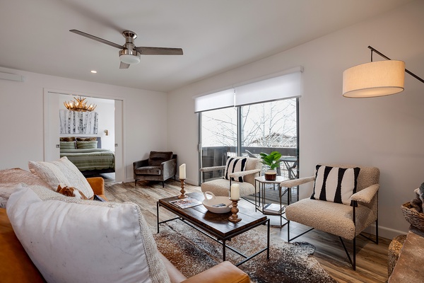 Unwind in this bright, beautifully styled living space where plush seating and warm textures invite you to relax. Natural light pours through expansive windows, framing peaceful winter views that enhance your getaway experience.