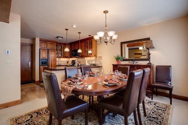 Gather around this elegant dining table, where your group can enjoy home-cooked meals together in comfort. Rich wood cabinetry and warm lighting create the perfect setting for memorable evenings.