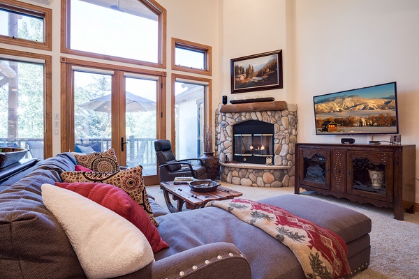 Sink into plush seating before a crackling stone fireplace while you enjoy mountain views through soaring windows and crisp, snowy scenery beyond your doorstep.