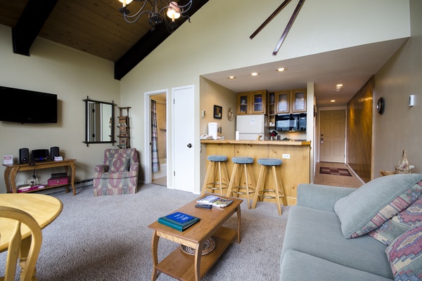 You'll love gathering in this open living space where vaulted ceilings with rustic beams create an airy feel and the fully equipped kitchen bar invites conversation over morning coffee or après-ski snacks.