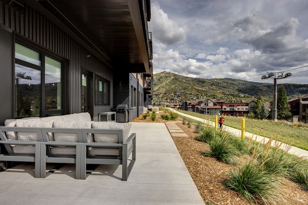 Spacious outdoor patio with modern seating where you can take in the surrounding mountain scenery and neighborhood charm from the comfort of your private space.