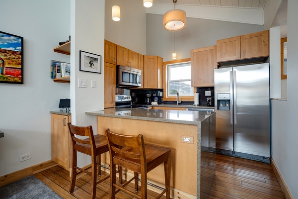 Your fully equipped kitchen features granite countertops, stainless steel appliances, and a breakfast bar where you can enjoy morning coffee or casual meals with mountain views.