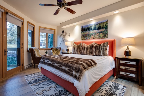 Step into your mountain retreat where crisp white linens and plush faux-fur bedding invite restful nights. Natural light streams through large windows as the ceiling fan keeps you comfortable year-round.