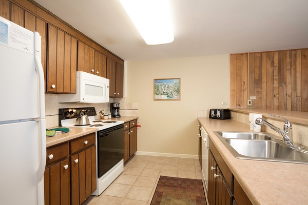 Your fully equipped kitchen provides everything you need to prepare meals during your stay, with warm wood cabinetry, modern appliances, ample counter space, and a homey mountain-inspired ambiance that makes cooking feel effortless.