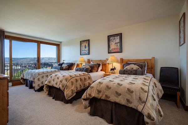 Wake up to stunning mountain vistas in your inviting bedroom, where rustic charm meets comfort. Three cozy beds and soft lighting create the perfect retreat after your day of adventure.