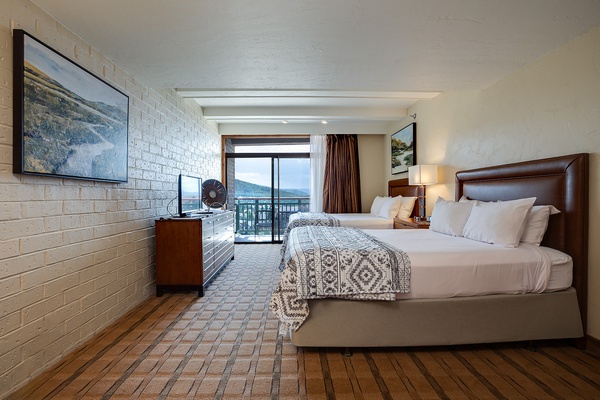 Wake to mountain views from your comfortable bed, where crisp linens and warm textures welcome you after adventure-filled days. Your private balcony brings the scenery right to your room.