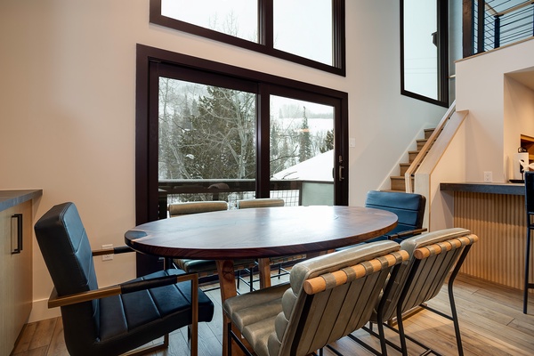 Gather around this elegant dining table with snowy mountain views streaming through floor-to-ceiling windows, where meals become memorable moments in your alpine retreat.