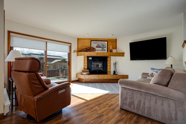 Sink into plush seating beside the warm glow of your fireplace, where sunlight streams through large windows and a flat-screen TV awaits your favorite shows.