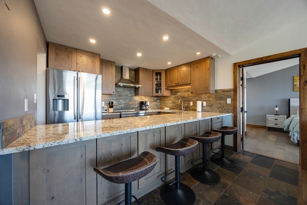 Gather around this spacious kitchen island with granite countertops, modern appliances, and rustic wood accents—your home base for cooking and conversation during your stay.