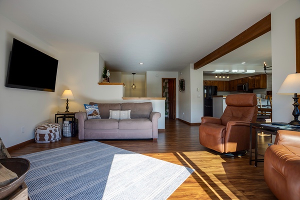 Sunlight streams through your open-concept space, where warm wood tones and cozy leather seating invite you to unwind in total comfort.