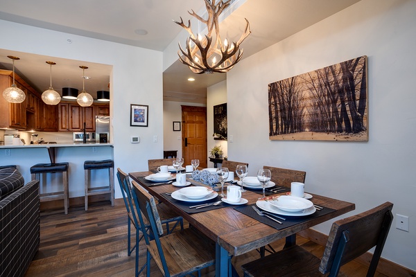 Gather around your rustic dining table under the striking antler chandelier, where mountain-inspired elegance meets comfort. The open-concept space flows effortlessly into a well-equipped kitchen, perfect for your group meals.