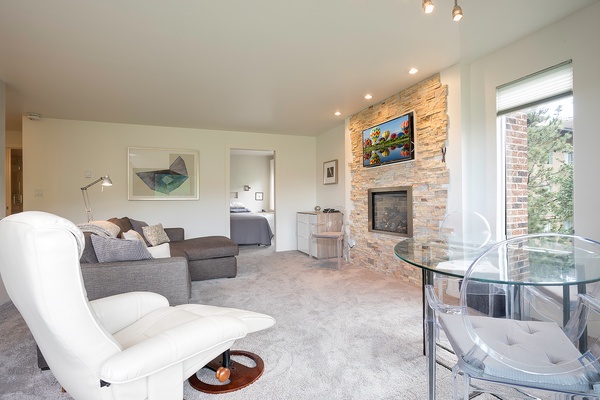 Unwind in your spacious living area with plush seating, a warm fireplace, and large windows inviting natural light. Perfect for relaxing after a day of adventures.