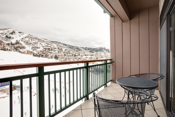 Enjoy breathtaking mountain views from your private balcony, where cozy seating invites you to sip morning coffee while soaking in the alpine beauty.