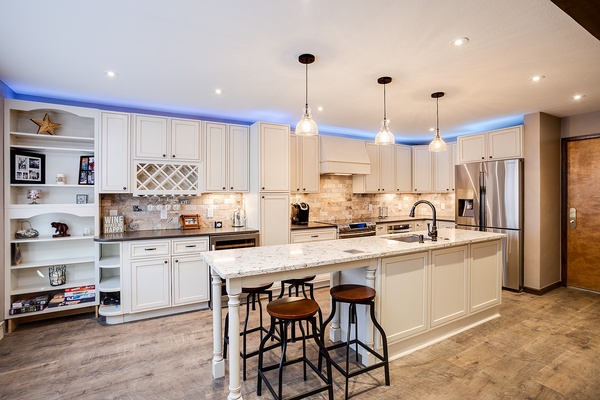 Gather around this spacious kitchen island with elegant white cabinetry, granite countertops, and modern appliances—perfect for whipping up your favorite meals and making memories.