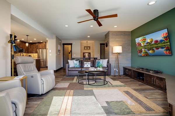 Sink into plush seating where warm wood tones meet modern comforts—your retreat features a smart TV, stylish furnishings, and an open flow to a fully equipped kitchen.