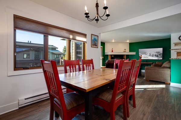 Gather around this inviting dining table where the vibrant red chairs and rich wood tones create the perfect setting for your group meals and mountain memories.