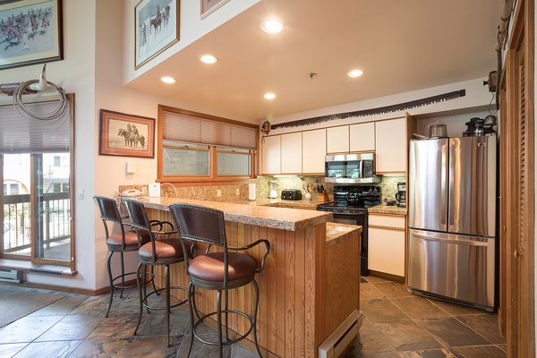 Your fully equipped kitchen awaits with granite counters, stainless appliances, and a cozy breakfast bar perfect for morning coffee or evening conversations with loved ones.