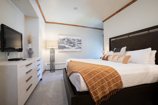 Sink into the plush bedding and unwind while watching your favorite shows. Warm wooden accents and soft lighting create a cozy retreat after your mountain adventures.