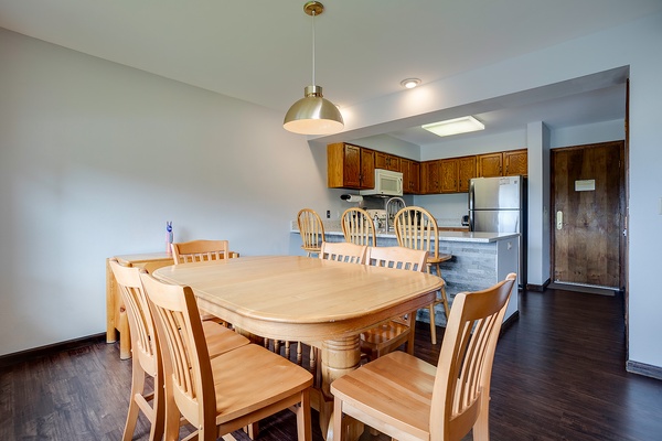 Step into your bright, open living area where a spacious dining table invites family meals and game nights. The full kitchen awaits your culinary adventures, complete with modern appliances and all the essentials.