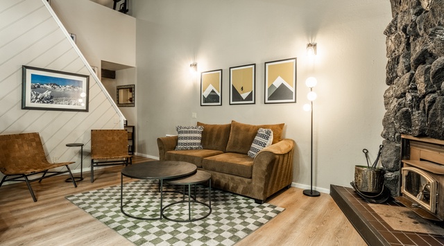 Settle into this cozy living space, where warm wood tones and a stone fireplace create your perfect mountain retreat after adventurous days exploring nearby trails.