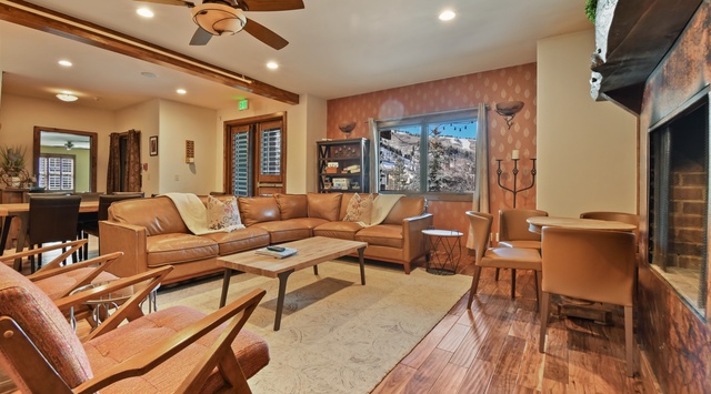 Sink into plush leather seating by your cozy fireplace, where mountain views frame relaxing evenings in this stylish living space.