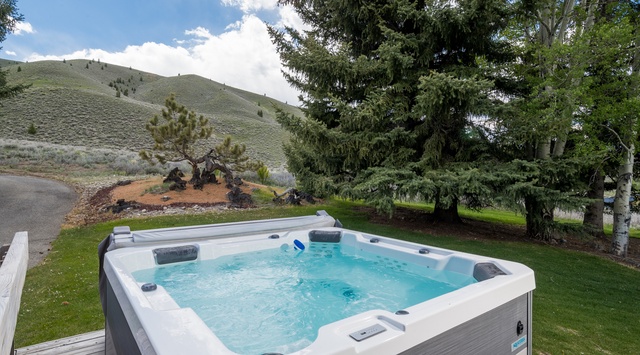 Soak in this private hot tub surrounded by towering evergreens and mountain views, a perfect retreat after exploring the area.