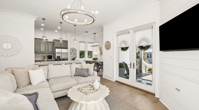 Sink into plush sofas in your open living space, where soft light floods through glass doors leading to your private outdoor retreat. Modern comforts blend with coastal charm.