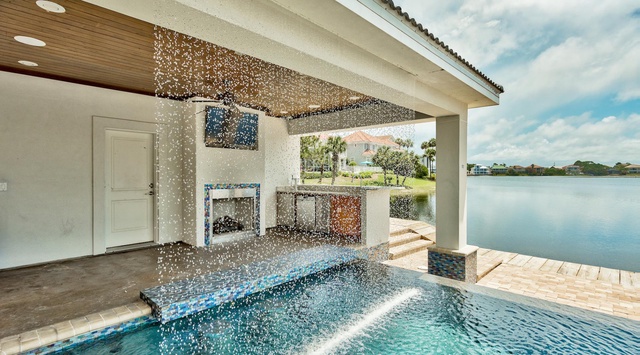 Dive into luxury with your private pool featuring sparkling water fountains and breathtaking lake views from your covered outdoor oasis.