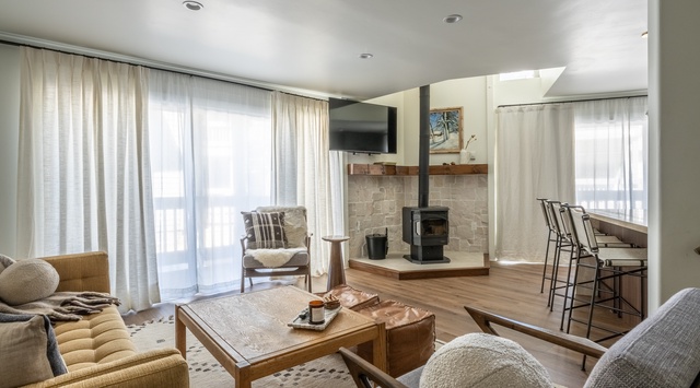 Unwind in your sophisticated living space featuring a cozy fireplace, plush seating, and warm wood accents that create the perfect atmosphere for relaxation.