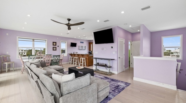 Unwind in this bright, open-concept living space where plush seating invites you to relax while enjoying stunning water views through expansive windows. Your perfect coastal retreat awaits.